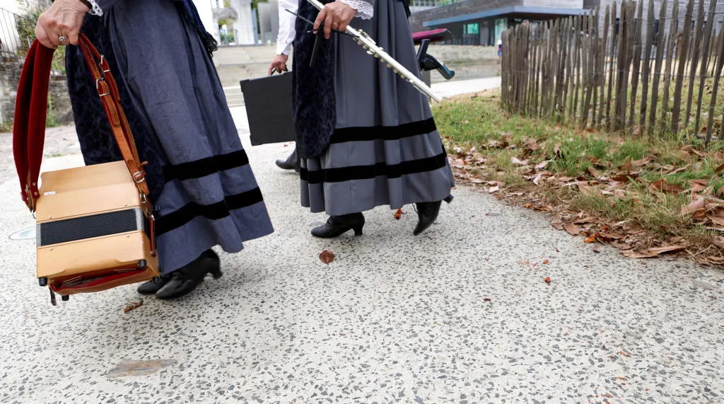 Danseuses en costume traditionnel breton portant leurs instruments