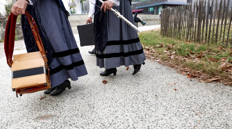 Danseuses en costume traditionnel breton portant leurs instruments