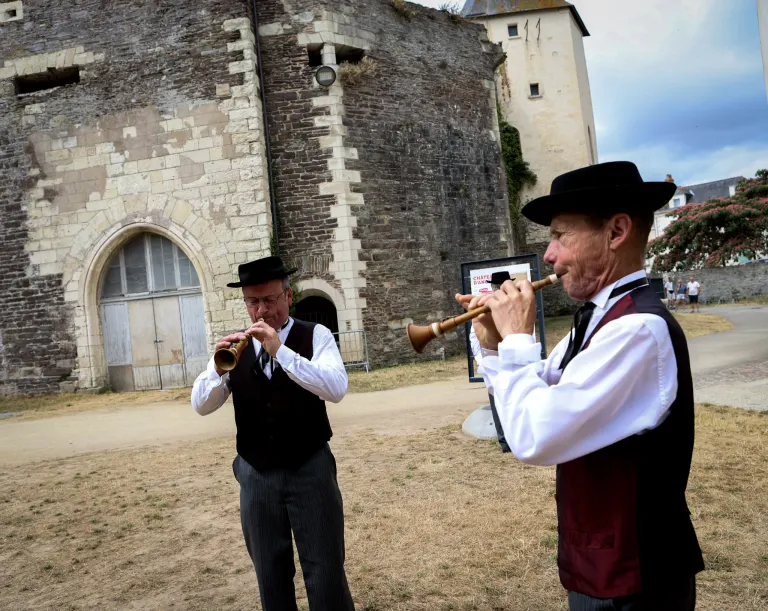 Deux sonneurs de bombarde en costume devant le château d'Ancenis