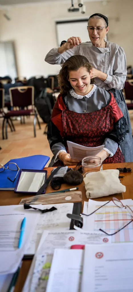 Pose d'une coiffe bretonne sur une danseuse avant le spectacle